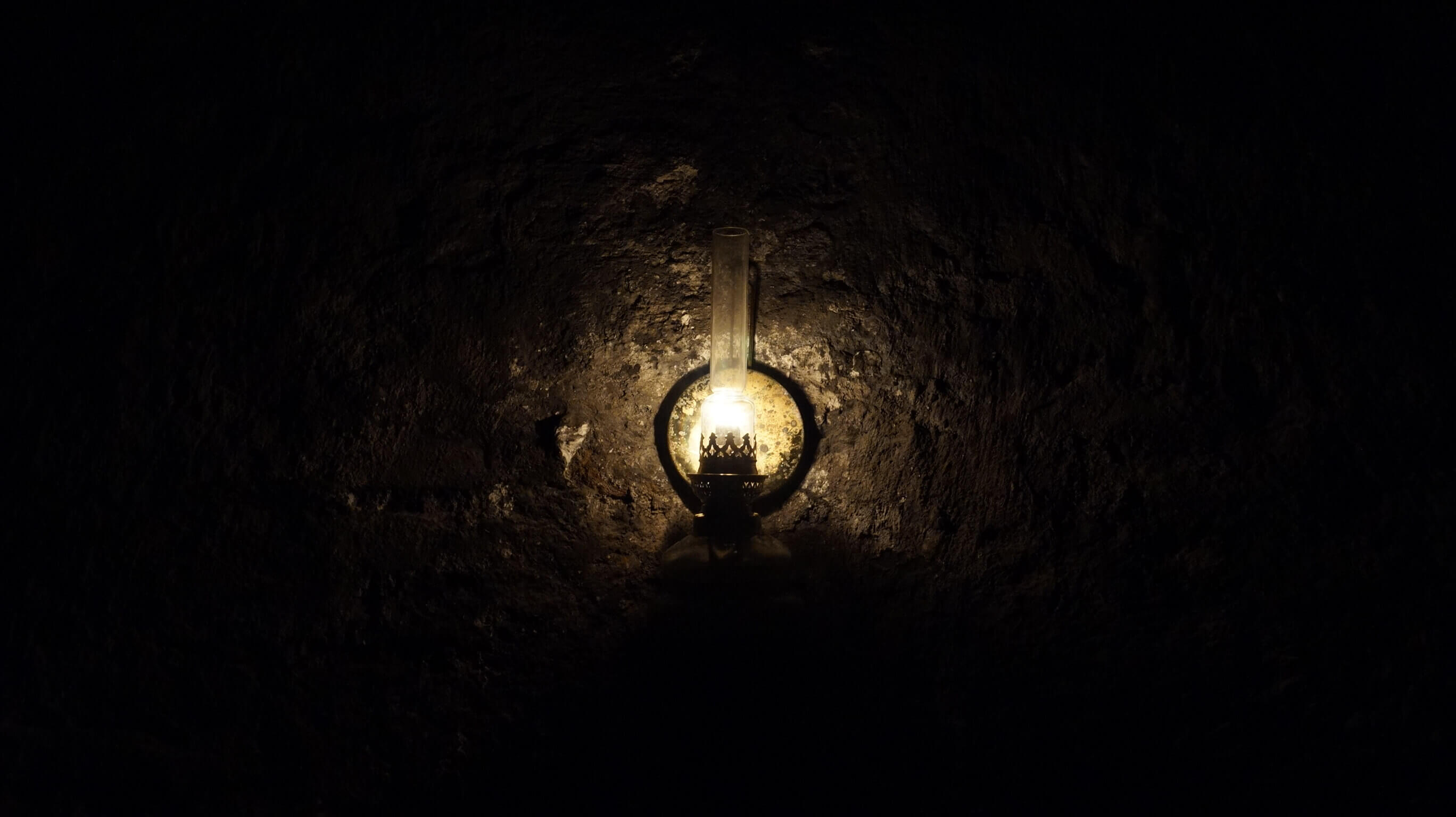 a Petroleum lamp in the dark on a stone wall