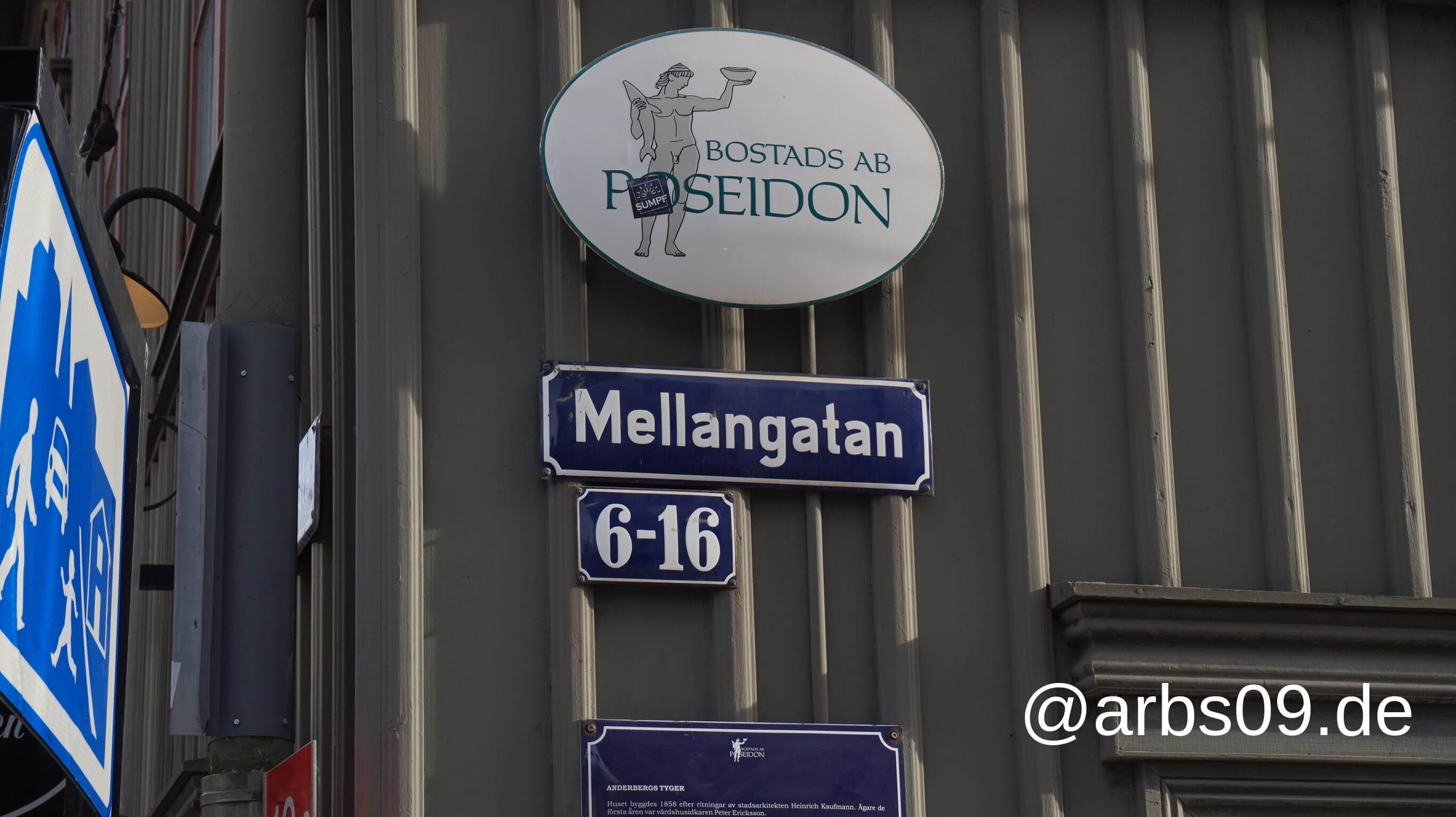 Street sign “Mellangatan” with house numbers 6-16 on a grey house